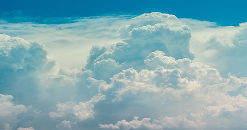 Fluffy white clouds against a vibrant blue sky.